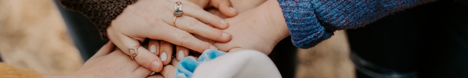 A close up of a group of hands laid on top of each other.