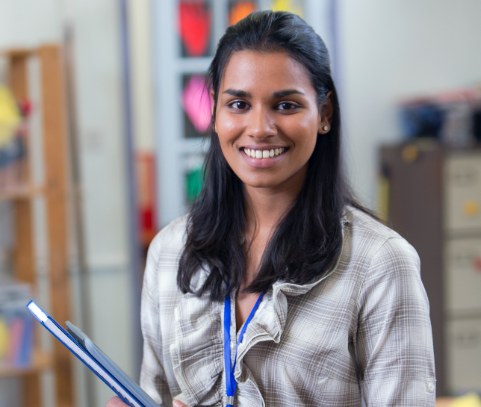 Young smiling woman carrying a notebook.