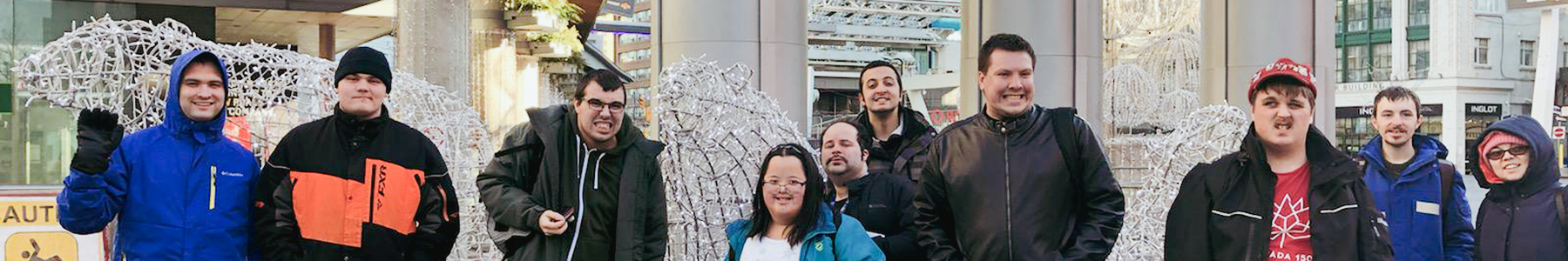 Ten Young adults standing in front of a lighted Christmas display.