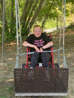 Person supported on a wheelchair swing