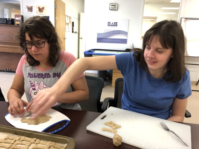 Photo shows two ladies making dog cookies and having fun